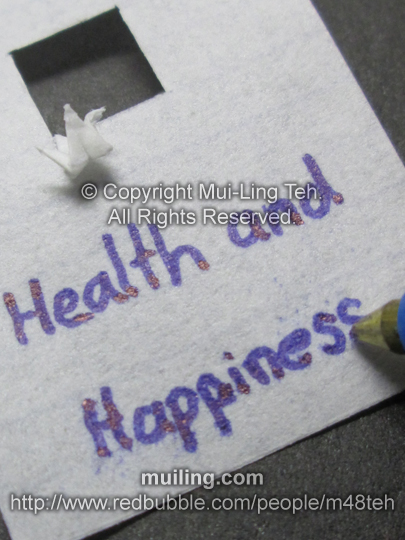 Miniature white origami crane with personalized message "Health and Happiness" by Mui-Ling Teh