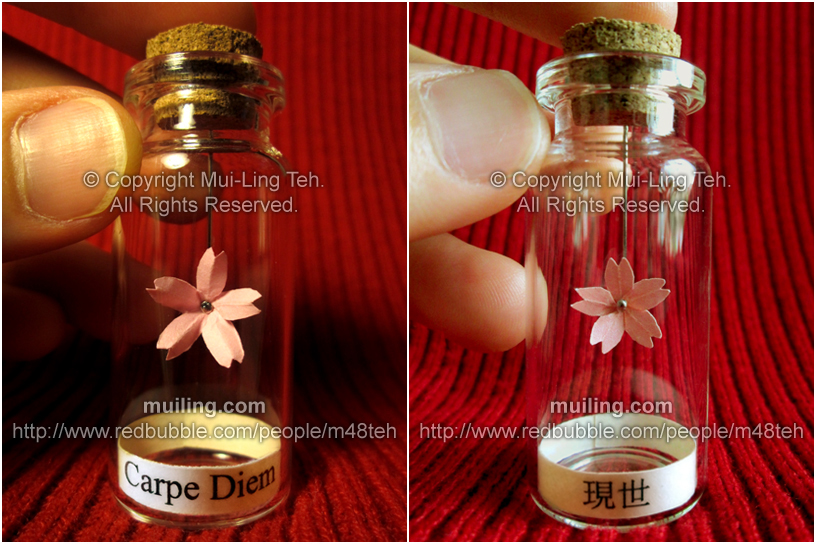 Miniature pink origami cherry blossom flowers by Mui-Ling Teh, hanging off a needles in bottle.