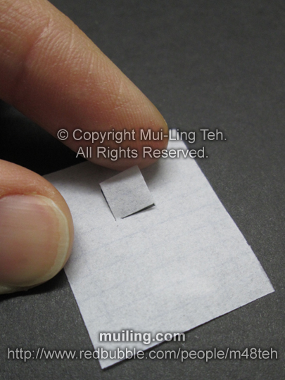 Cut white paper used to fold miniature origami crane