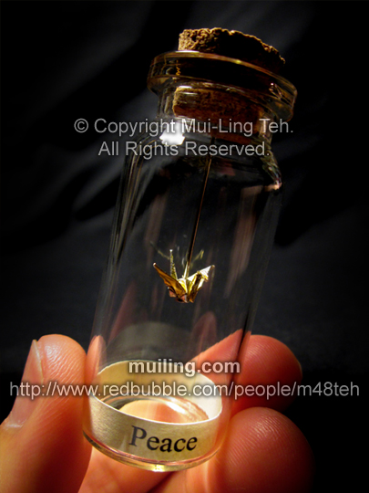 Miniature gold origami crane in a bottle with the word Peace by Mui-Ling Teh