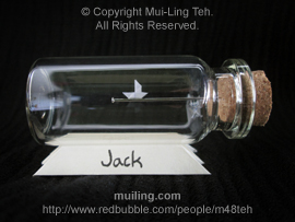 Miniature origami boat sailing along a needle in a bottle by Mui-Ling Teh, personalized with the name "Jack" written on the yellow base at the bottom.