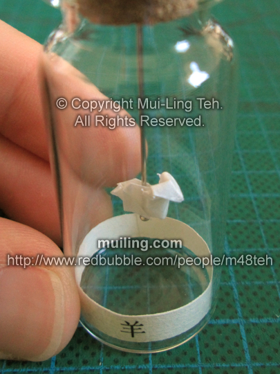 Cute white miniature origami goat in a bottle from the Shengxiao Chinese circle of animals zodiac