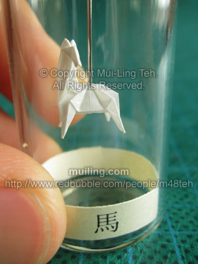 Cute white miniature origami horse in a bottle from the Shengxiao Chinese circle of animals zodiac