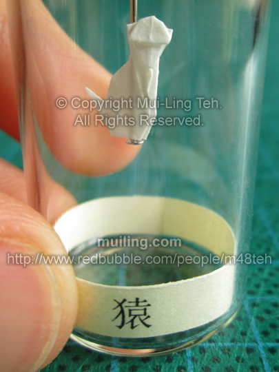 Cute white miniature origami monkey in a bottle from the Shengxiao Chinese circle of animals zodiac