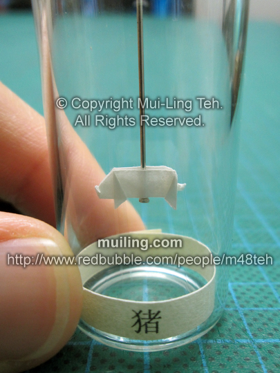 Cute white miniature origami pig in a bottle from the Shengxiao Chinese circle of animals zodiac
