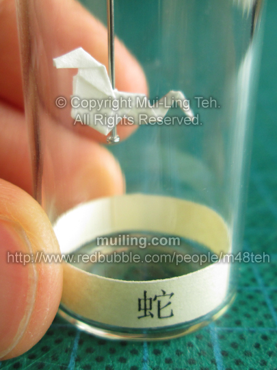 Cute white miniature origami snake in a bottle from the Shengxiao Chinese circle of animals zodiac