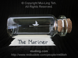 Miniature origami boat sailing along a needle in a bottle by Mui-Ling Teh, personalized with the boat name "The Mariner" written on the yellow base at the bottom.