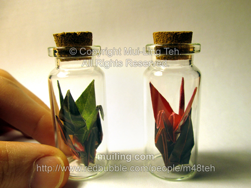 Colourful origami cranes in small bottles by miniature origami artist Mui-Ling Teh