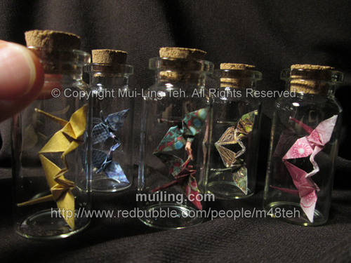bottled origami kissing cranes in small bottles folded by miniature origami artist Mui-Ling Teh