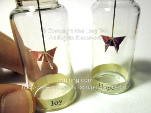 Colourful miniature origami butterflies in bottles, with the label "Joy" and "Hope"