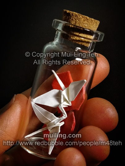 origami kissing cranes and stacked hearts in a small bottle by Mui-Ling Teh