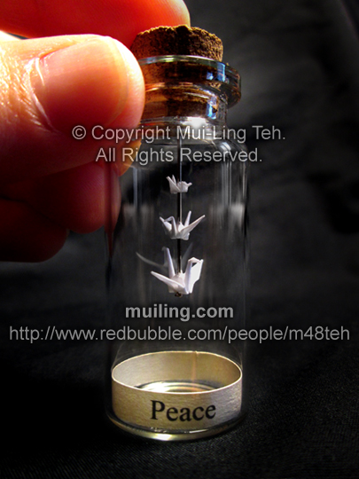 Three bottled miniature origami cranes with the word Peace by Mui-Ling Teh