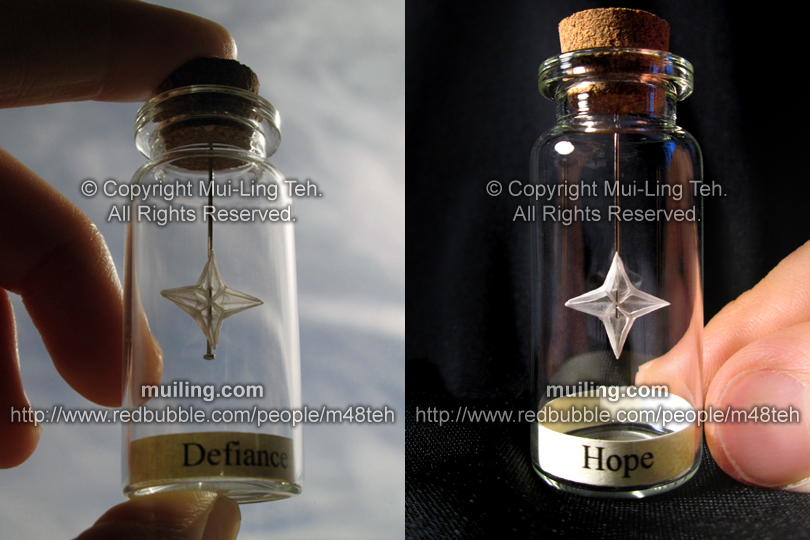 Miniature translcuent white origami stars/snowflakes in small bottles by Mui-Ling Teh, with the words 'Defiance' and 'Hope' written on yellow labesl
