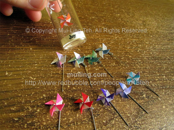 Colourful miniature origami pinwheels in bottles